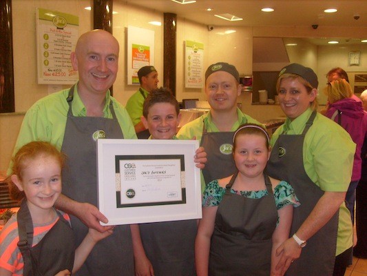 Joe McGee receiving his Customer Service Excellence Ireland recognition along with family and staff
