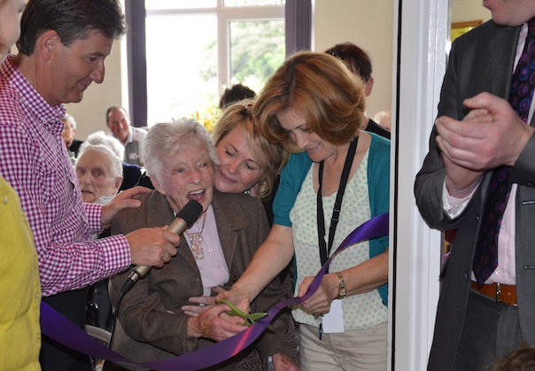 Madge O'Donnell cutting the ribbon assisted by Sue Islam, Director of Nursing at Dungloe Hospital on the right and Daniel O'Donnell on the left. 