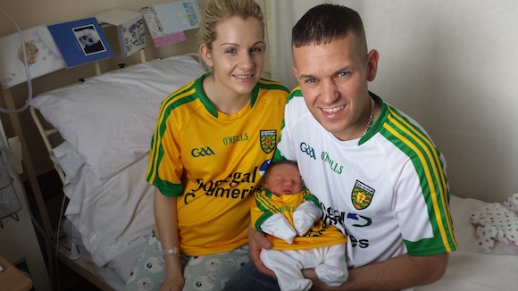 Proud parents Claire Higgins and Odhran Grant with newborn son Daithi in their Donegal jerseys.