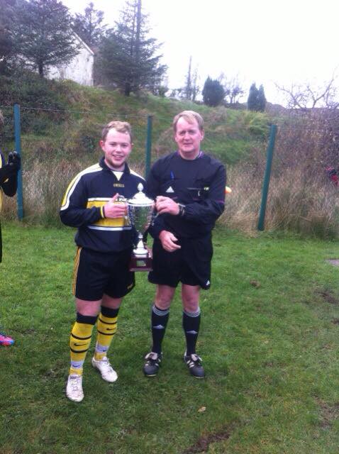 RCS captain Aidan Gillespie receives the cup from referee Marty Quinn. 