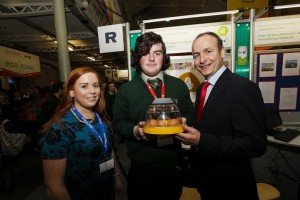 Fianna Fáil Leader Micheál Martin pictured with teacher Rachel McGuiness and Jack McDermott from Moville Community College, Co Donegal with their project titled ' To Investigate if the shape of an egg affects the hatch rate in chickens' at the BT Young Scientist Exhibition at the RDS. The 2015 Exhibition received its highest ever number of entries, over 2000 projects from more than 360 schools across Ireland. Picture Conor McCabe Photography.