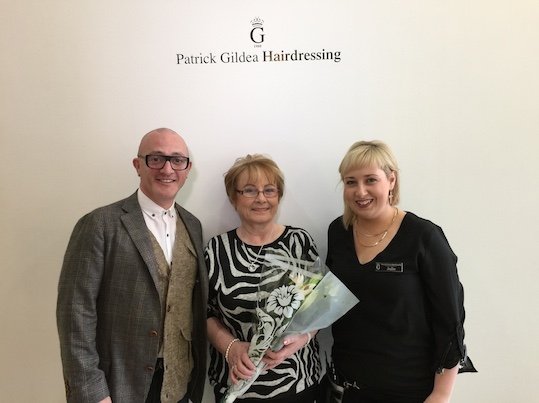Mary Brown being presented with some lovely flowers by Patrick Gildea and staff member Julie.