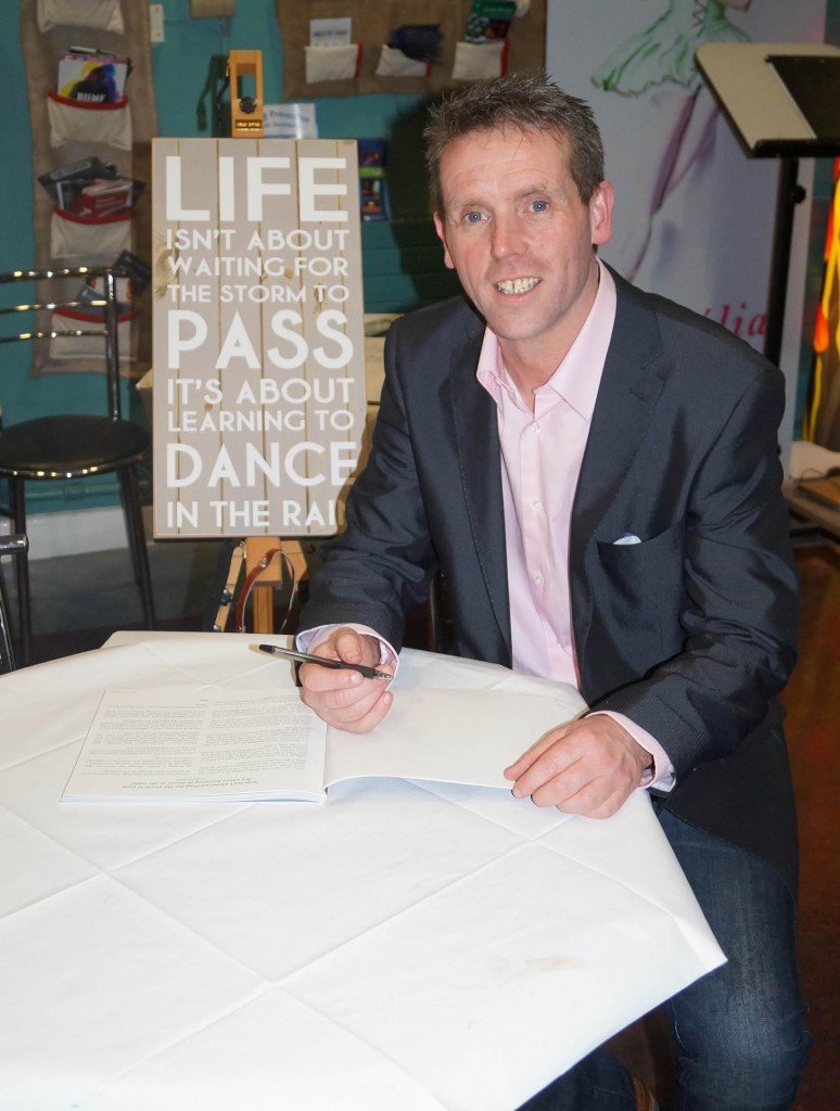 Liam Porter pictured signing a copy of his new book ‘Dance in the Rain’ at An Grianan Theatre last Thursday night.