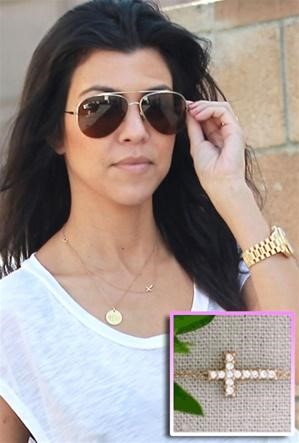 Kourtney Kardashian wearing a single pendant layered with a simple cross. 