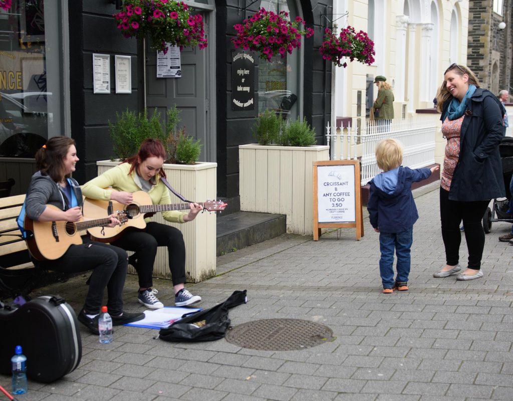 A young lad looking ofr money for buskers Niamh O'Raw  and Emer McLaughlin from Buncrana taking part in the Letterkenny Chamber Shop LK busking Competition in Letterkenny on Saturday last.  Photo Clive Wasson