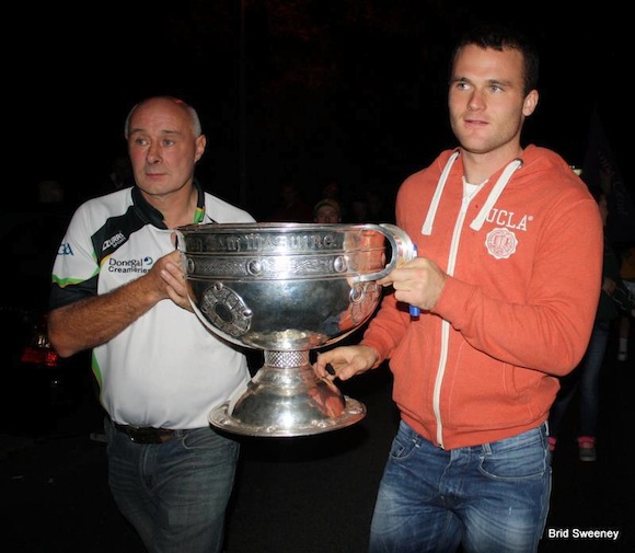 Neil McGee & his father Éamonn carry the Sam Maguire into the Gaoth Dobhair clubhouse last night. Pic Brid Sweeney