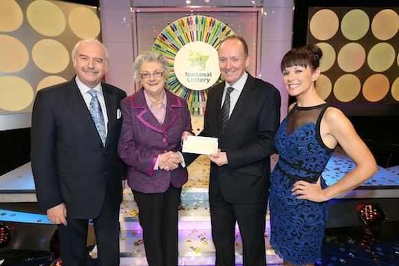 Rita McElhinney from Manorcunningham Co Donegal has won €20,000 as the Dream Player on the National Lottery Winning Streak TV game show hold in RTE. Pictured at the presentation of winning cheques were from left: Marty Whelan, game show host. Rita McElhinney, winner.  Declan Harrington, Head of Finance The National Lottery and Geri Maye, game show host. Pic Mac Innes Photography