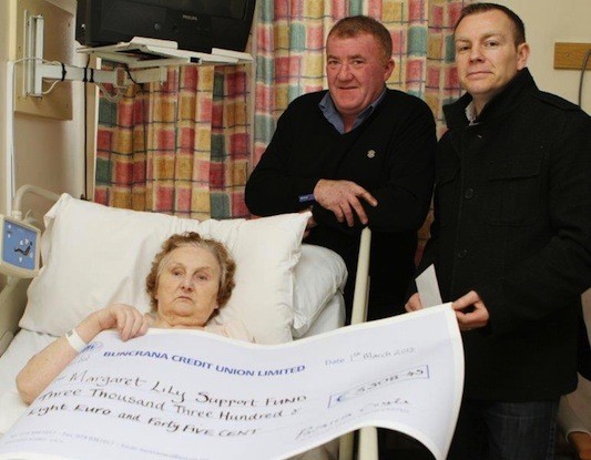 Margaret Lilly with neighbour Robbie Callaghan and Cllr Ciaran McLaughlin receiving her support cheque for more than €3,380