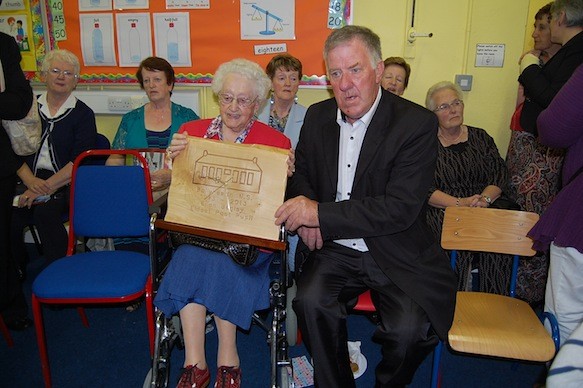 The oldest person present who attended school Ellen Begley being presented with clock from  Committee chairperson John Mc Dermott.