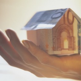 Hand Holding Paper House Made of Euro Notes