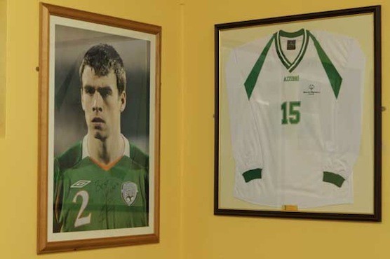 A photo of Seamus Coleman beside a picture of his brother Stephen's Ireland jersey which is hanging on the walls of local St Catherines FC