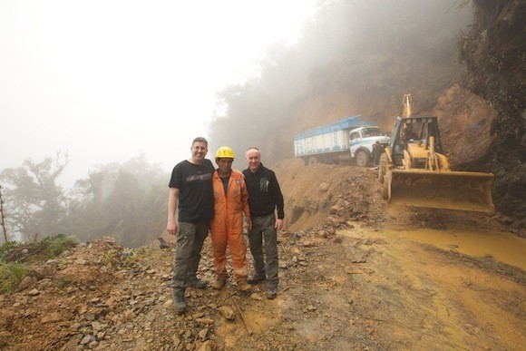 The lads cross a road just hours after it had been covered and then cleared by a landslide.
