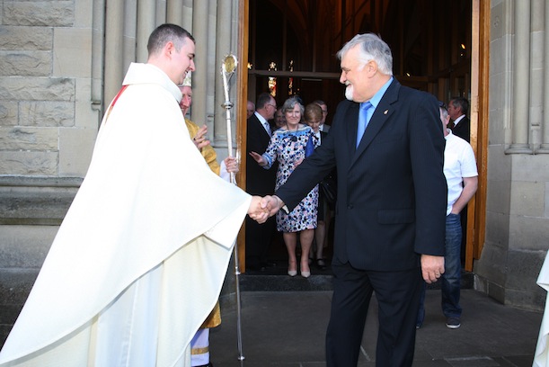 Neighbour John Baird congratulates Fr Gorman following his ordination Photo Brian McDaid