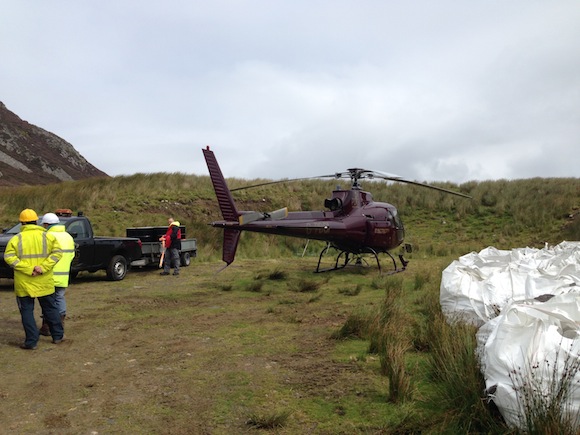 The chopper begins to take loads of stone up to the cliff pathways.