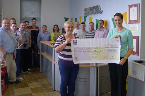 Anne Marie Doherty, the mother of 5 year old Killygordon boy Paul, is presented with a cheque for  €934.50 towards the Mammy I Want To Walk Fund from SITA staff member Leona Barron.
