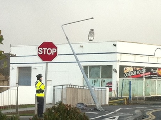 The light hangs from the ESB pole after the crash as Gardai stand watch. PIc by Donegal Daily.
