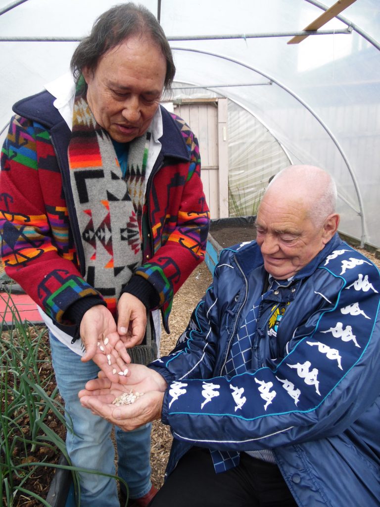 Photo: Tony Dalton Falcarragh community gardener receives Choctaw heirloom squash seeds from AFRI organiser Waylon White Deer. 