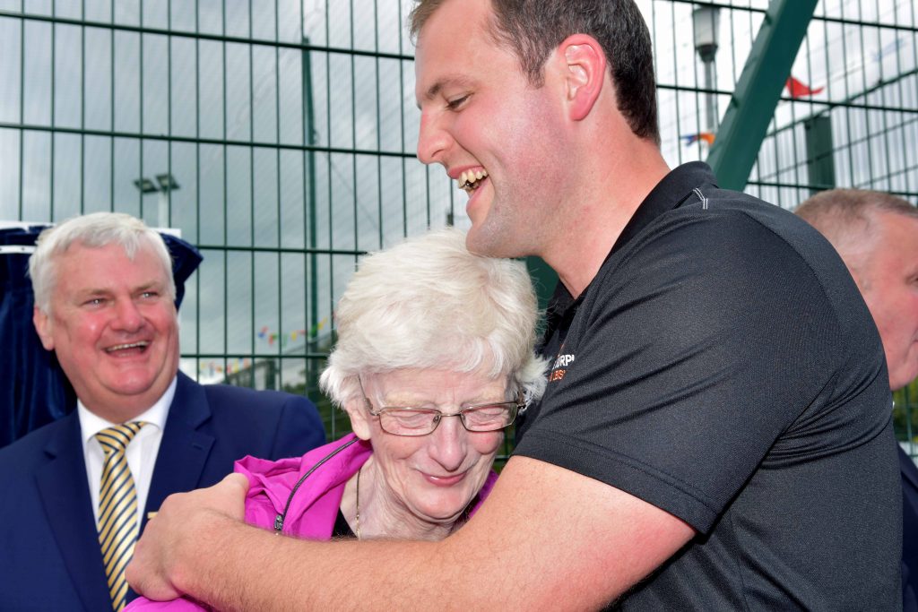 Aogan O Fearghail, Uachtaran Chumann Luthchleas Gael looks on as Sally Mc Clafferty gets a hug from Donegal GAA Captain Michael Murphy at the opening of the new astro pitch at Strath Mor. Photo: Geraldine Diver