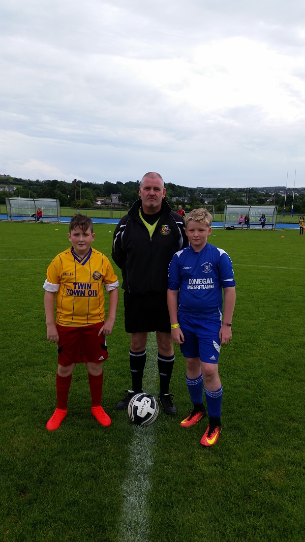 Captains Ethan Deery and Cahir Brady Devenny with match referee John Coyle.